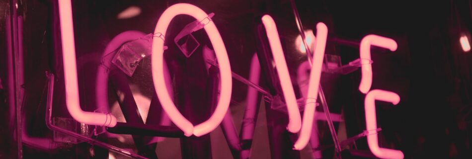 A pink neon sign that says, "Love."