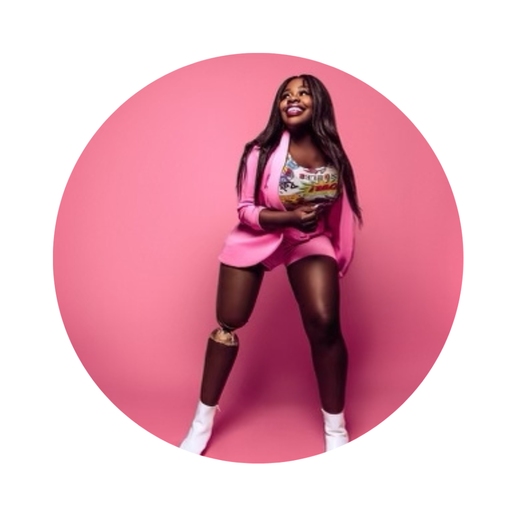 A photo of Marsha Elle, a Black woman with a bionic leg smiling with a pink background.