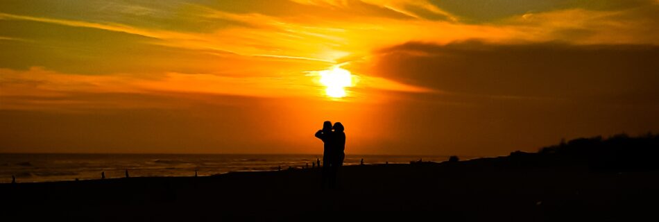 A sunset with a silhouette of a couple.